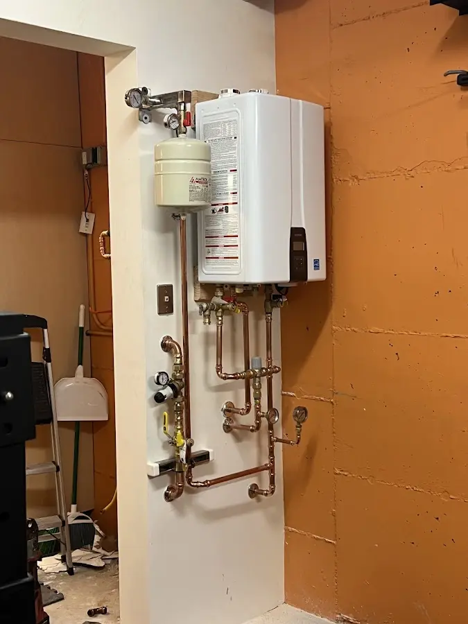 Plumbing technician inspecting water heater connections in Sea Cliff